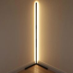 a light that is shining on the wall in an empty room with wood flooring