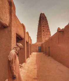 a man standing in front of some adobe buildings