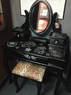 a black vanity with leopard print stool and mirror