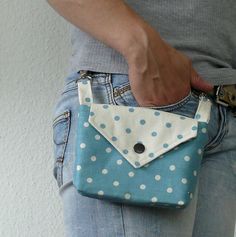 a person is holding a polka dot purse in their hand and the pocket has a button on it