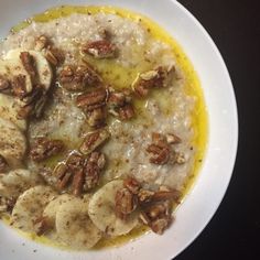 a white plate topped with oatmeal and nuts