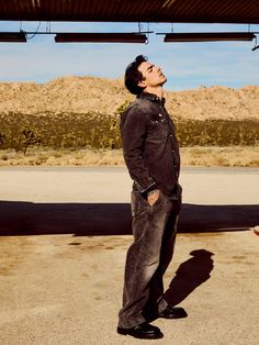 a man standing in the middle of an empty parking lot with his eyes closed looking up