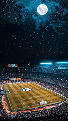 a stadium full of people watching a tennis match at night with the moon in the sky