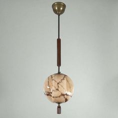 a marbled light fixture hanging from a metal pole with a wooden handle and two lights on each side