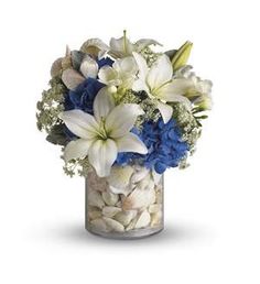 a vase filled with white and blue flowers