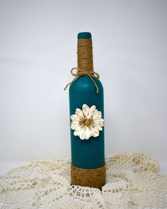 a bottle with a flower on it sitting on a doily