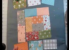 someone is making a quilt with squares and flowers on the fabric, which have been cut into smaller squares