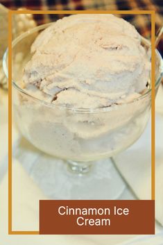 a glass bowl filled with ice cream sitting on top of a white tablecloth covered table