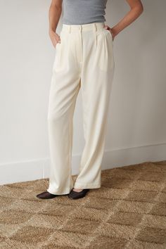 drawing inspiration from traditional suiting with a twist, our pleated trouser is one of our favorite classic go-to styles - ready to take you anywhere feeling polished and comfortable. plus, it's made from cellulose fibers so it's better for the planet. features: mother of pearl button belt loops pockets + pleats twill woven texture made in la pairs perfectly with the crop vest about the fabric: our twill fabric is a soft woven crafted from lyocell fibers derived from cellulose wood pulp, which Chic Cream Bottoms With Pressed Crease, Cream Straight Hem Bottoms For Work, Elegant Pants With Button Closure And Straight Hem, Tailored Cream Wide Leg Pants For Work, Cream Workwear Pants With Pressed Crease, Classic Cream Wide Leg Pants For Work, Cream Wide Leg Pants With Belt Loops, Cream Pants With Pressed Crease For Work, Cream Pants With Belt Loops For Work