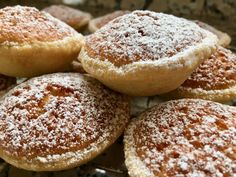 powdered sugar covered pastries sitting on top of a cooling rack