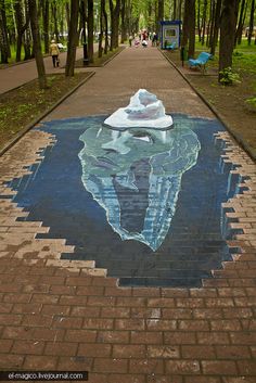 a brick sidewalk with a painted image of an iceberg on it