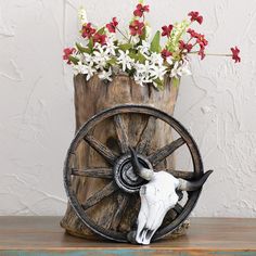 a vase with flowers in it and a steer's skull on the table next to it