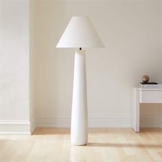 a white lamp sitting on top of a wooden floor