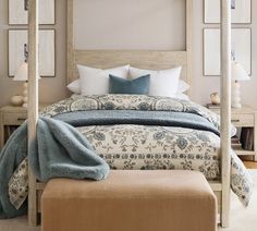 a bedroom with a four poster bed covered in blue and white blankets