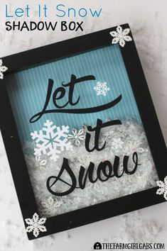 a black and blue frame with snowflakes on it that says let it snow