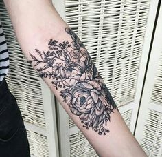 a black and white flower tattoo on the arm