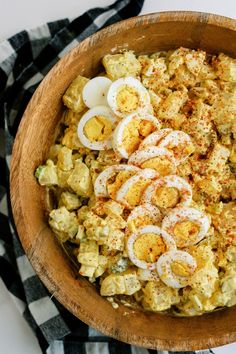 a wooden bowl filled with eggs and other food