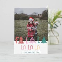 a christmas card with the word fa la la on it and a photo of two children