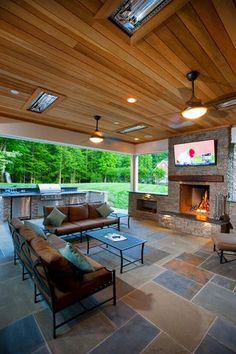 an outdoor living room with fireplace and seating area