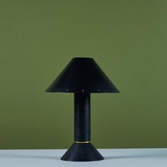 a black lamp sitting on top of a table next to a green wall and floor