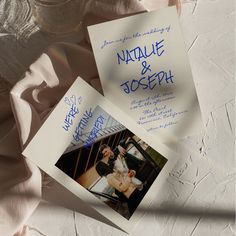 two wedding cards are laying on top of each other with the same photo attached to them