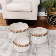 three white baskets sitting on top of a rug