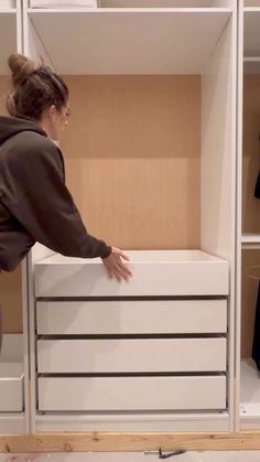 a woman reaching into a closet with drawers