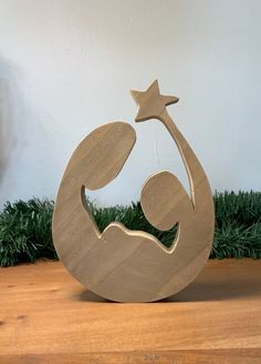 a wooden nativity ornament with a star in the middle on a table