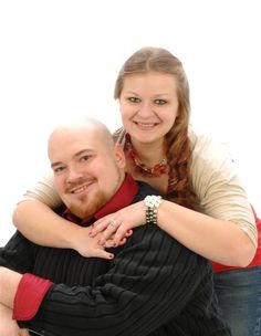 a man and woman hugging each other while posing for the camera with their arms around each other