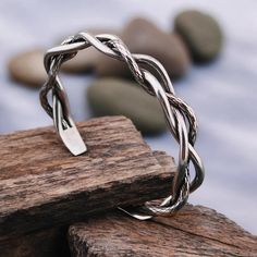 a silver ring sitting on top of a piece of wood