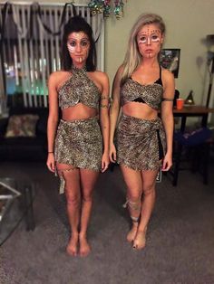 two women dressed in animal print outfits standing next to each other with makeup on their faces