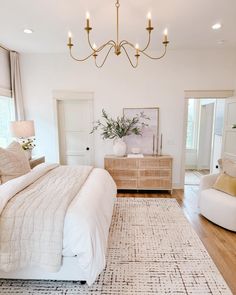 a bedroom with a bed, chair and chandelier in the middle of it