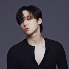 a young man with black hair wearing a black shirt