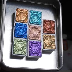 four different colored squares in a metal container