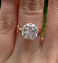 a woman's hand with a ring on it and a diamond in the middle