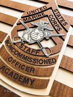 the marine office sign is made out of wood and has an eagle on it's side