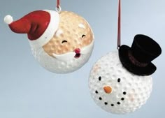 two christmas ornaments hanging from strings in the shape of snowman and santa clause hats