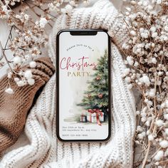 a cell phone sitting on top of a white blanket next to some flowers and branches