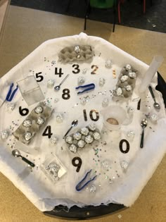 the table is covered with silver and black numbers, scissors, and other things to make it look like they have been made into a clock