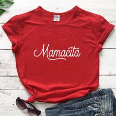 a red shirt with the word mamacit on it and some sunglasses next to it