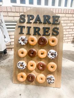 a wooden sign with donuts on it that says spare tires and is decorated with chocolate sprinkles