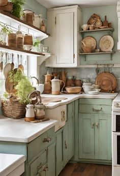 a kitchen filled with lots of green cabinets and white counter top space next to an oven