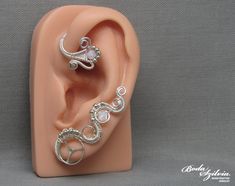 Wire wrapped crystal steampunk ear wrap in silver, no piercing required. It's made of nickel free silver plated wire, a recycled stainless steel watch wheel, seed beads and white swarovski crystal beads. Available: - left ear - right ear - pair Plz, select from the list (select style). You can find more ear wraps here: https://www.etsy.com/shop/bodaszilvia?section_id=10953132&ref=shopsection_leftnav_4 Plz, read my policies before buying. Thank you! If you are interested in news, work in progress Whimsical Adjustable Wire Wrapped Ear Cuff, Unique Silver Adjustable Body Jewelry, Adjustable Silver Whimsical Ear Cuff, Whimsical Adjustable Silver Ear Cuff, Sterling Silver Ear Cuff With Ear Wire For Weddings, Elegant Wire Wrapped Metal Cartilage Earrings, Silver Wire Wrapped Body Jewelry Gift, Bohemian Silver Wire Wrapped Earrings, Silver Sterling Silver Wrap Earrings For Wedding