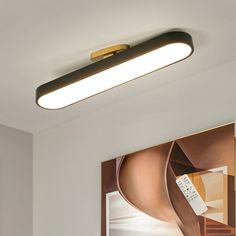 a modern ceiling light with remote control on the wall in a living room or bedroom