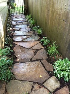 a stone path in front of a wooden fence