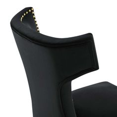 an upholstered black chair with gold studding on the armrests and back