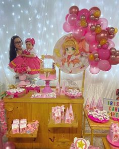 a birthday party with pink and gold decorations, balloons, cake and other items on the table