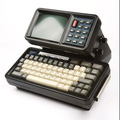 an old fashioned computer with a keyboard and monitor on it's back side,