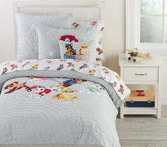 a bed with mickey mouse comforter and matching pillowcases in a bedroom setting