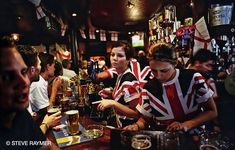 some people are sitting at a bar with beers